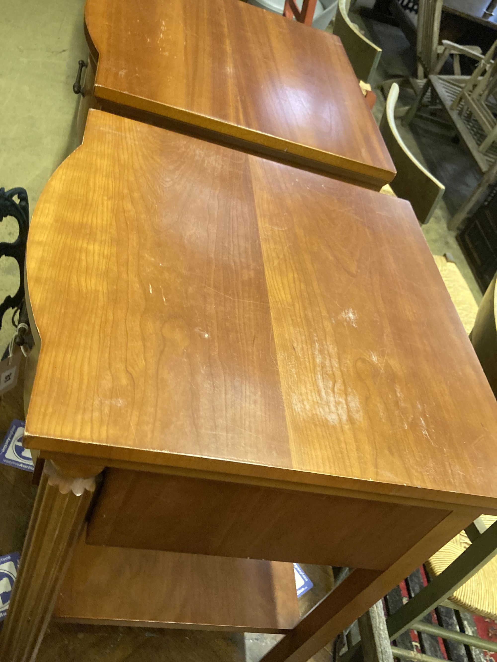 A pair of walnut bowfront two tier bedside tables, width 50cm, depth 50cm, height 61cm